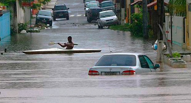 Nesta imagem aparecem inúmeros carros afundados na água em uma rodovia.